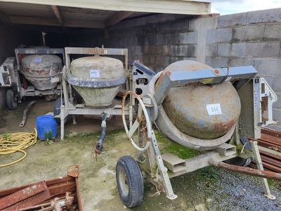 a cement mixer in a garage with other cement mixers in the background