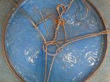a blue plate with a rope wrapped around it on the floor