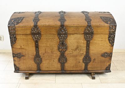 a wooden trunk sitting on top of a tiled floor