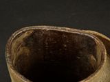 a close up of a brown vase on a black surface
