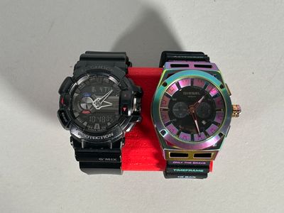 two watches that are sitting next to each other on a table
