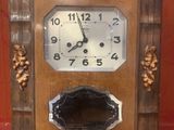 une horloge en bois posée sur une surface rouge