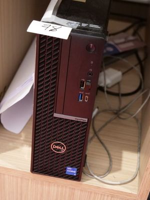 un petit ordinateur posé sur un bureau en bois