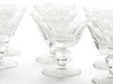 several empty wine glasses are lined up on a white surface