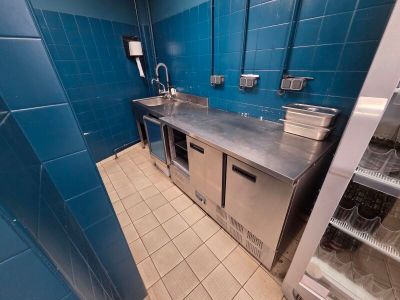 a kitchen with blue tiles and stainless steel counter tops