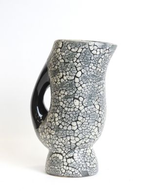 a black and white vase sitting on a white surface