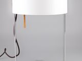 une lampe blanche posée sur une table, à côté d'une autre lampe blanche