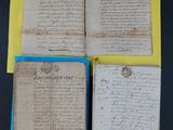 three pages of old paper with writing on them sitting on a table