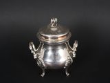 an antique silverplated teapot with a lid on a black background