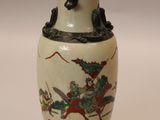 a vase with a painting on it sitting on a table