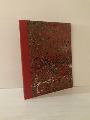 Le livre est posé sur une surface blanche et présente une couverture rouge.