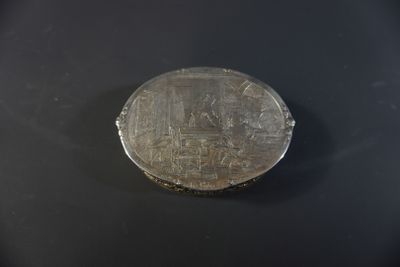 a silver coin sitting on top of a black surface