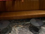 deux tables et un banc dans un coin de la pièce
