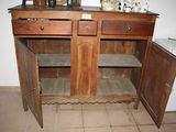 a wooden cabinet with two doors open and a sink