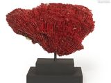 an image of a red coral sculpture on a black stand