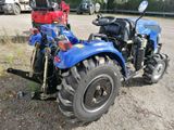 a blue tractor parked on the side of the road