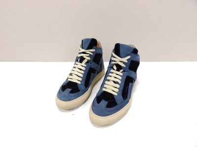 une paire de baskets bleues avec des lacets blancs sur un fond blanc