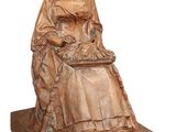 statue représentant une femme assise sur une chaise, tenant un panier de laine