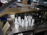 many cups and mugs sitting on the counter in the kitchen