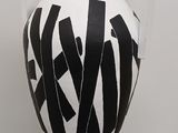 a black and white vase on a pedestal in a room