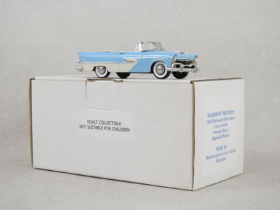 une petite voiture jouet bleue et blanche posée sur une boîte