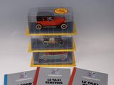 trois boîtes de petites voitures posées sur une table