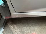 a close up of a car door with a red spot on the floor