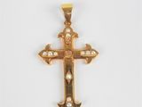 un pendentif en forme de croix en or serti de diamants sur fond blanc