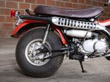 a red and black motorcycle parked in front of a brick wall