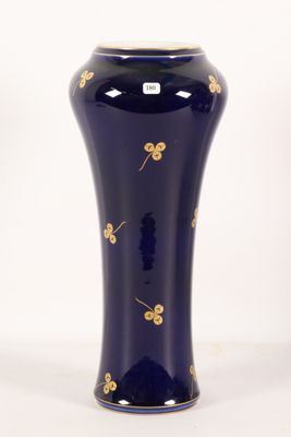 a blue vase with gold flowers on it on a white background