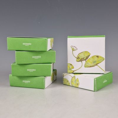 trois boîtes de thé vert posées sur une table blanche