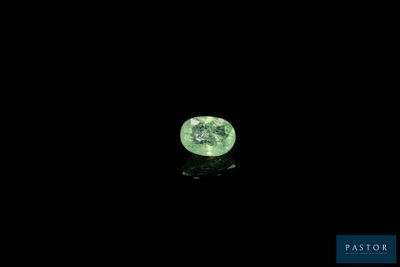 a close up of a green diamond on a black surface