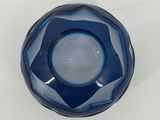 a blue glass candle holder on a white table