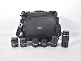 a black camera bag with a lot of lenses on it
