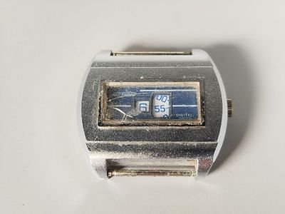 une montre argentée et bleue posée sur une surface blanche