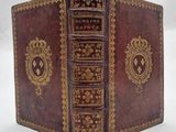 un vieux livre relié en cuir, orné de bordures dorées et de motifs élaborés