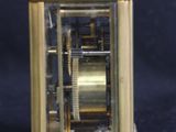 a small gold clock with a pair of scissors next to it