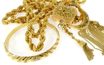 a lot of gold jewelry on a white surface