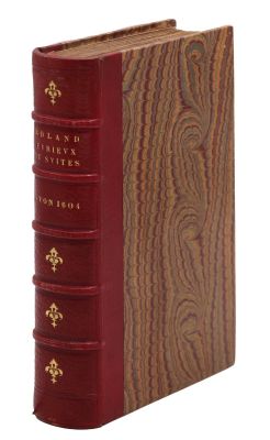 un vieux livre à la couverture rouge posé sur une table en bois