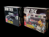 two boxes of star trek games on a black background