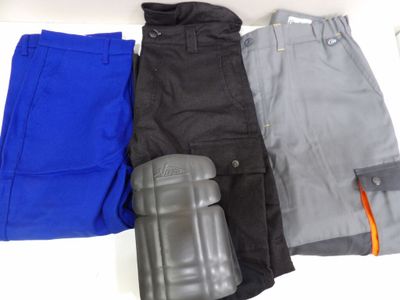 trois paires de pantalons pour homme et des genouillères posés sur une surface blanche