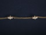 a close up of a gold chain bracelet with silver beads