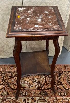 une petite table avec un plateau en marbre posée sur un tapis