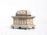 an old wooden box with carvings on top of it on a white surface