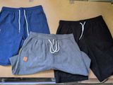 three pairs of men ' s shorts sitting in a box