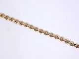 a close up of a gold bracelet on a white surface