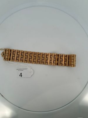 a gold bracelet on a white plate with a number 4 on it