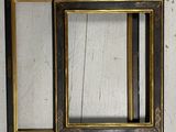two black and gold picture frames hanging on a wall next to each other