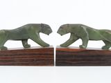these are two statues of two elephants on a wooden base