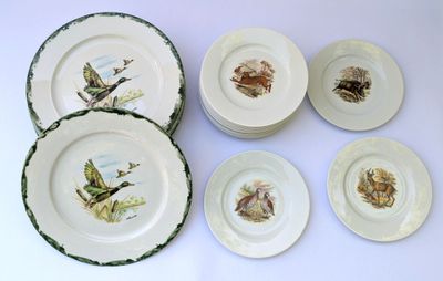 six plates with birds painted on them sitting on a table